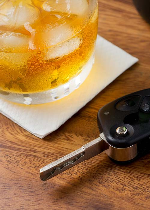 бокал с алкоголем и ключи от машины на столе
